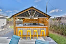 Modern coastal getaway with pool enclosed yard grill and outdoor bar