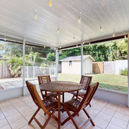 Screened porch with string lights and backyard at a Largo home