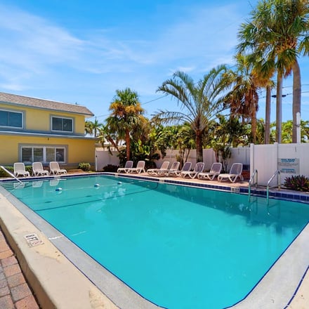 Heated pool with palm trees at a St. Pete Beach property