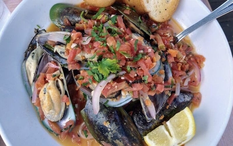 Steamed mussels in tomato broth with crusty bread at Fresco's