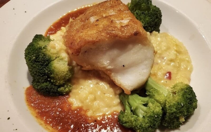 Pan-seared grouper over cheese grits with tomato sauce and broccoli
