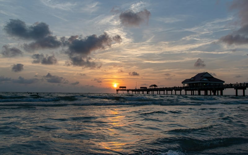 Clearwater Beach pier at sunrise with waves rolling in