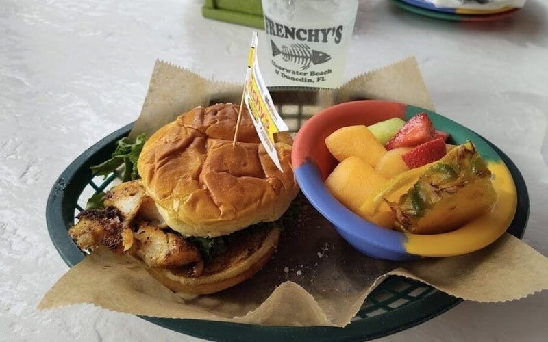 Grilled fish sandwich with fresh fruit at Frenchy's Rockaway Grill
