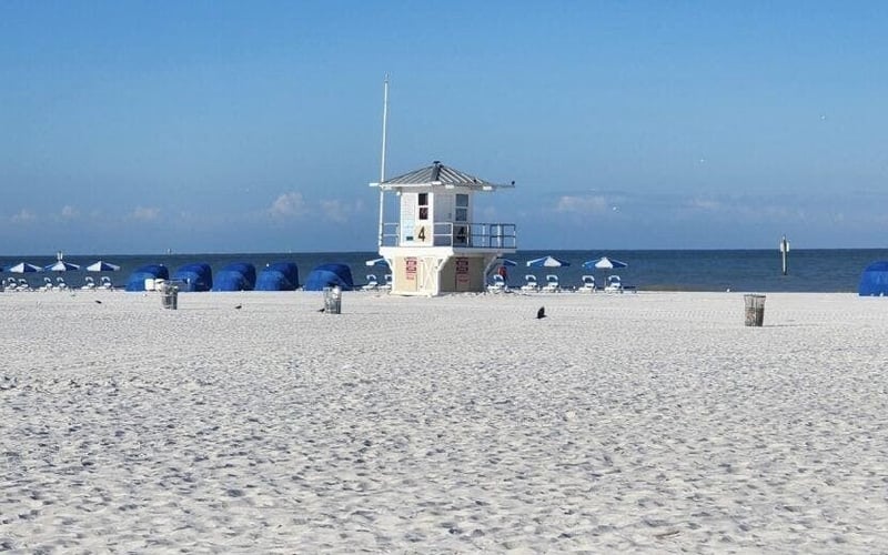 Lifeguard tower on Clearwater Beach with blue umbrella rentals